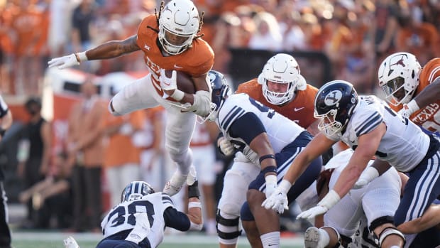 Texas Longhorns running back Jonathon Brooks jumps over BYU Cougars safety Crew Wakley in the third quarter at Royal-Memorial