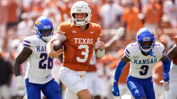 Texas Longhorns quarterback Quinn Ewers runs past Kansas Jayhawks linebacker, left, and cornerback Mello Dotson for a touchdown in the first quarter at Royal-Memorial Stadium on Saturday September 30, 2023.