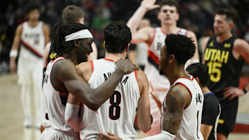 Oct 18, 2024; Portland, Oregon, USA; Portland Trail Blazers forward Deni Avdija (8) is helped up during the second half by teammates Portland Trail Blazers forward Jerami Grant (9), left, and guard Anfernee Simons (1) against the Utah Jazz at Moda Center. Mandatory Credit: Troy Wayrynen-Imagn Images