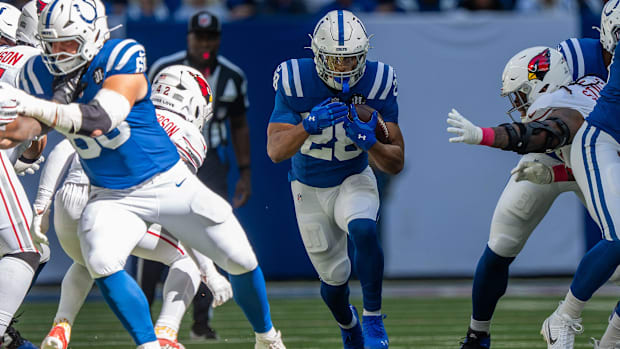 Colts running back Jonathan Taylor (Blue and White Uniform) carrying the football. 