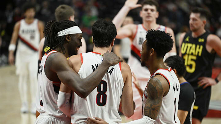 Oct 18, 2024; Portland, Oregon, USA; Portland Trail Blazers forward Deni Avdija (8) is helped up during the second half by teammates Portland Trail Blazers forward Jerami Grant (9), left, and guard Anfernee Simons (1) against the Utah Jazz at Moda Center. Mandatory Credit: Troy Wayrynen-Imagn Images