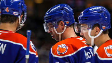 Bakersfield forward Greg McKegg (14) talks with defenseman Cam Dineen (4) and other teammates during a break in play during the third period of their game at Acrisure Arena in Palm Desert, Calif., Saturday, Dec. 16, 2023.