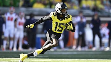 Oct 26, 2024; Eugene, Oregon, USA; Oregon Ducks wide receiver Tez Johnson (15) catches a pass for a touchdown during the first half against Illinois Fighting Illini defensive back Xavier Scott (14) at Autzen Stadium. Mandatory Credit: Troy Wayrynen-Imagn Images