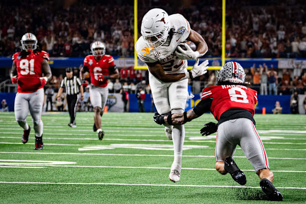 Texas Longhorns running back Jaydon Blue runs around defense from Ohio State Buckeyes safety Lathan Ransom 