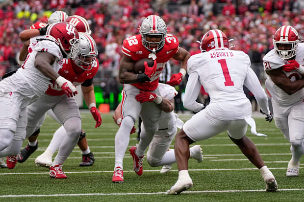 Buckeyes running back TreVeyon Henderson runs with the ball through the Hoosiers defense.