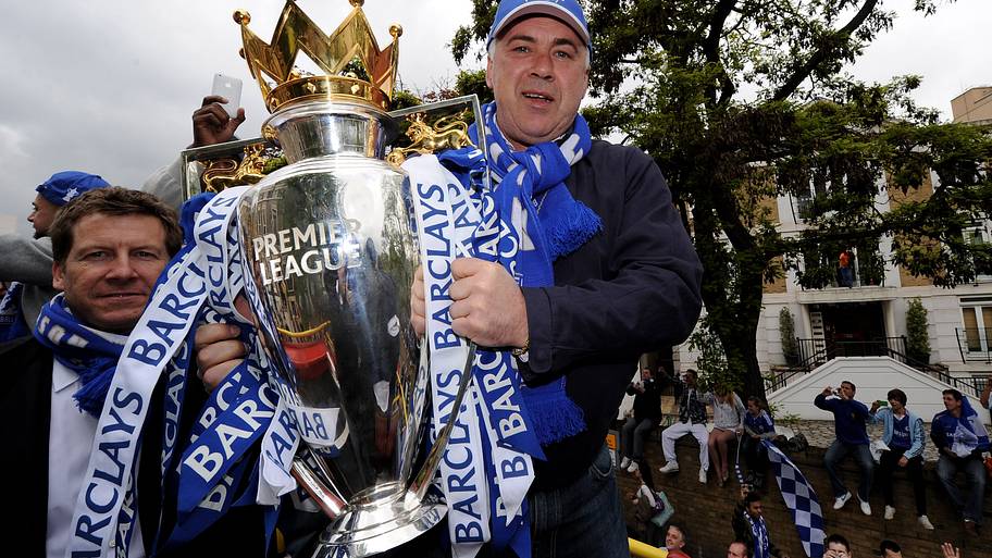 Carlo Ancelotti holding the Premier League trophy.