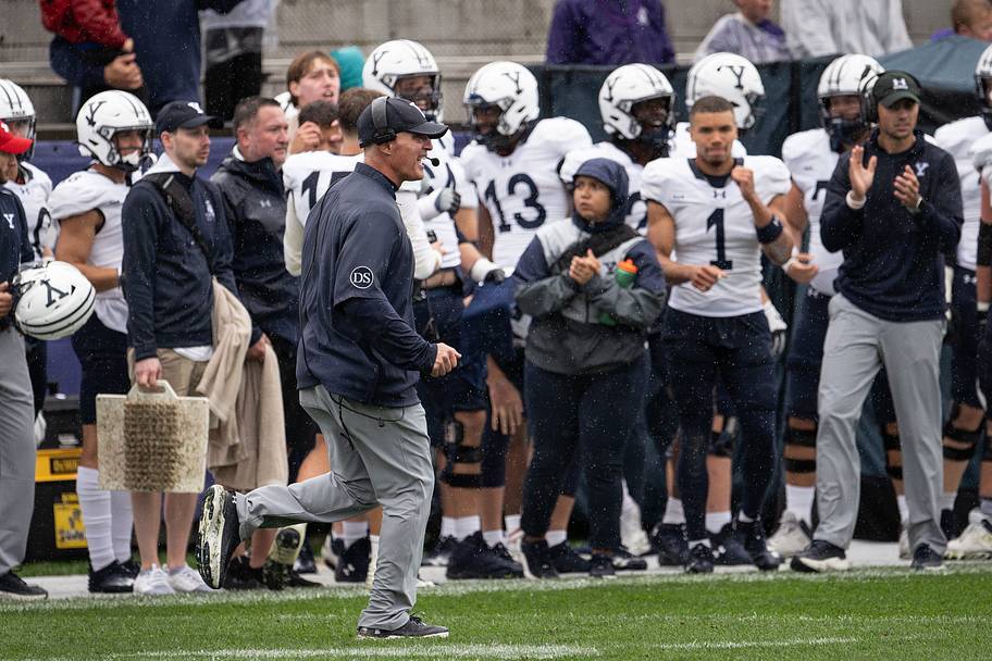Yale head coach Tony Reno celebrates a field goal that gives the Bulldogs a 17–14 lead over Holy Cross.