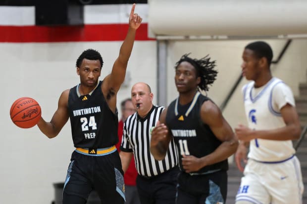 Basketball player points up during game.