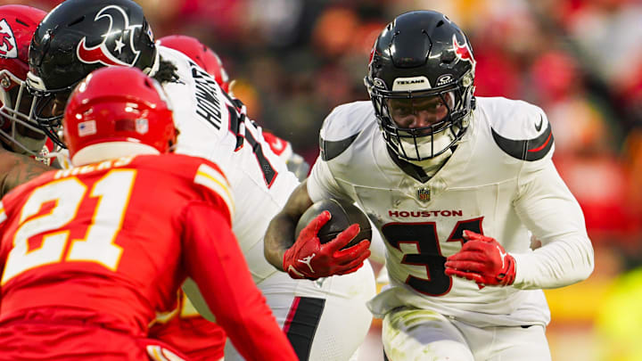 Jan 18, 2025; Kansas City, Missouri, USA; Houston Texans running back Dameon Pierce (31) runs the ball against Kansas City Chiefs safety Jaden Hicks (21) during the second half in a 2025 AFC divisional round game at GEHA Field at Arrowhead Stadium. Mandatory Credit: Jay Biggerstaff-Imagn Images