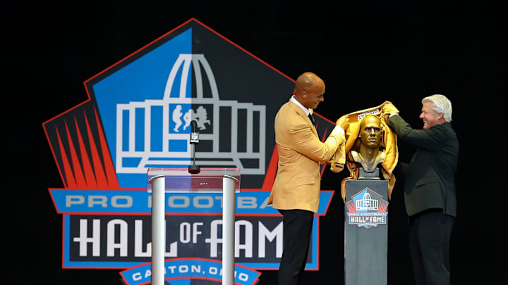 Aug 5, 2017; Canton, OH, USA; Jason Taylor pulls back the cloth of his bust with Jimmy Johnson (right) during the 2017 NFL Hall of Fame enshrinement at Tom Benson Hall of Fame Stadium. Mandatory Credit: Aaron Doster-Imagn Images