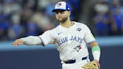 Nov 1, 2025; Toronto, Ontario, CAN; Toronto Blue Jays designated hitter Bo Bichette (11) throws to first for an out against Los Angeles Dodgers second baseman Tommy Edman (25) in the eighth inning during game seven of the 2025 MLB World Series at Rogers Centre. Mandatory Credit: John E. Sokolowski-Imagn Images