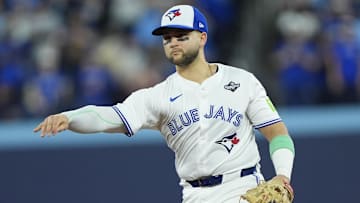 Nov 1, 2025; Toronto, Ontario, CAN; Toronto Blue Jays designated hitter Bo Bichette (11) throws to first for an out against Los Angeles Dodgers second baseman Tommy Edman (25) in the eighth inning during game seven of the 2025 MLB World Series at Rogers Centre. Mandatory Credit: John E. Sokolowski-Imagn Images