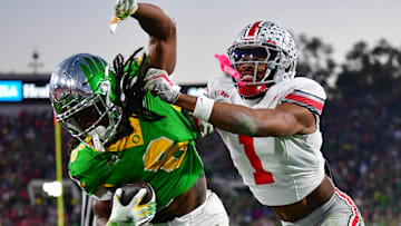 Jan 1, 2025; Pasadena, CA, USA;  Ohio State Buckeyes cornerback Davison Igbinosun (1) pushes Oregon Ducks running back Noah Whittington (6) out of bounds in the second half in the 2025 Rose Bowl college football quarterfinal game at Rose Bowl Stadium. Mandatory Credit: Gary A. Vasquez-Imagn Images