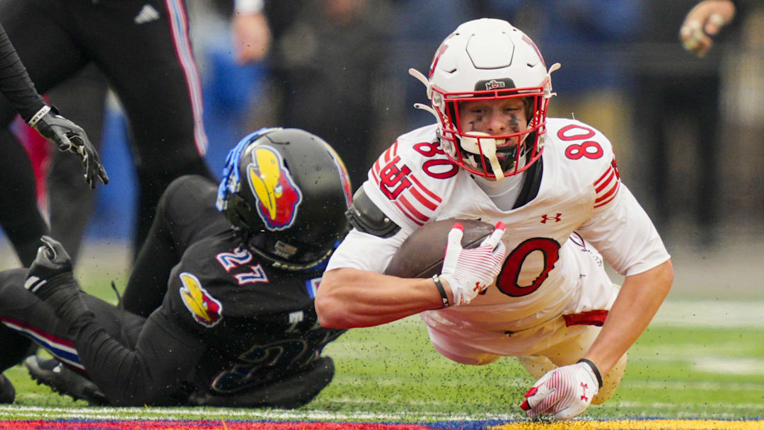 Utah Utes wide receiver Creed Whittemore (80) dives forward during the second half against the Kansas Jayhawks at David Booth Kansas Memorial Stadium.