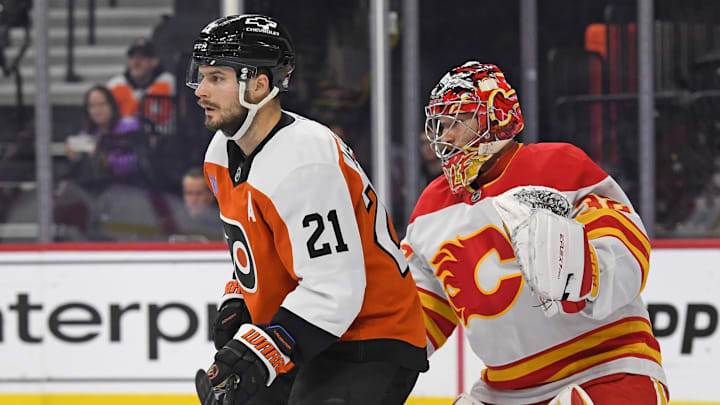Mar 4, 2025; Philadelphia, Pennsylvania, USA; Philadelphia Flyers center Scott Laughton (21) screens Calgary Flames goaltender Dustin Wolf (32) during the first period at Wells Fargo Center. Mandatory Credit: Eric Hartline-Imagn Images