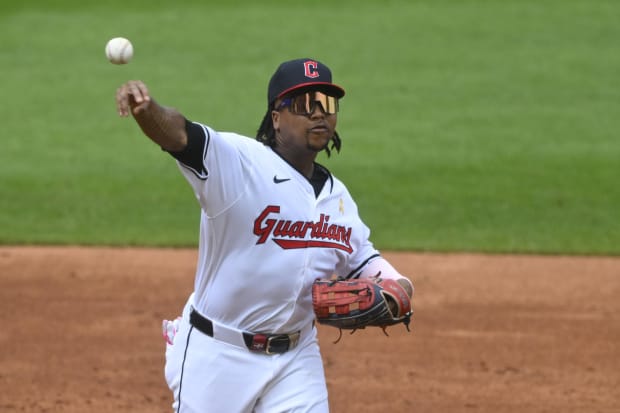 Jose Ramirez throws a ball to first base 