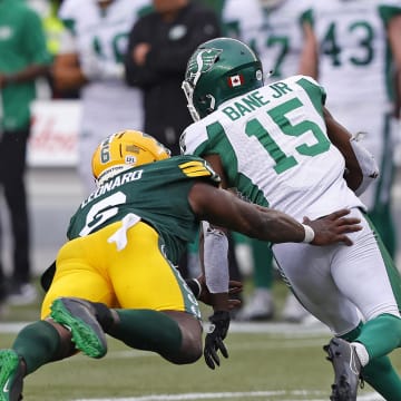 Jun 11, 2023; Edmonton, Alberta, CAN;  Saskatchewan Roughriders wide receiver Shawn Bane Jr. (15) avoids a tackle by Edmonton Elks defensive lineman A.C. Leonard (6) during the second half at Commonwealth Stadium. Mandatory Credit: Perry Nelson-USA TODAY Sports