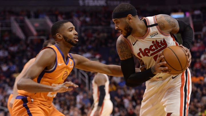 Mar 6, 2020; Phoenix, Arizona, USA; Portland Trail Blazers forward Carmelo Anthony (right) controls the ball against Phoenix Suns forward Mikal Bridges (25) during the second half at Talking Stick Resort Arena. Mandatory Credit: Joe Camporeale-USA TODAY Sports