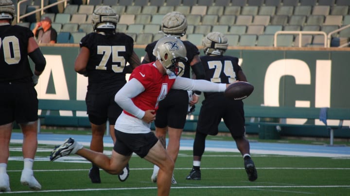 Derek Carr and the Saints offensive line go through drills during their training camp practice at Tulane's Yulman Stadium.