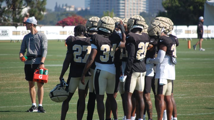 Saints defensive backs meet before breaking up into drills at training camp.