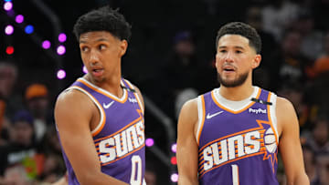 Nov 6, 2024; Phoenix, Arizona, USA; Phoenix Suns forward Ryan Dunn (0) and Phoenix Suns guard Devin Booker (1) look on against the Miami Heat during the first half at Footprint Center. Mandatory Credit: Joe Camporeale-Imagn Images
