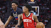 Jan 1, 2024; Houston, Texas, USA; Houston Rockets forward Amen Thompson (1) controls the ball as Detroit Pistons forward Ausar Thompson (9) defends during the fourth quarter at Toyota Center. Mandatory Credit: Troy Taormina-Imagn Images