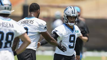 Carolina Panthers quarterback Bryce Young high fives tight end Ja'Tavion Sanders.