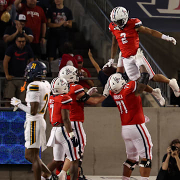 Sep 7, 2024; Tucson, Arizona, USA; Arizona Wildcats wide receiver Jeremiah Patterson (2) celebrates a touchdown with Arizona Wildcats offensive lineman Jonah Savaiinaea (71) during the third quarter against Northern Arizona Lumberjacks at Arizona Stadium. 