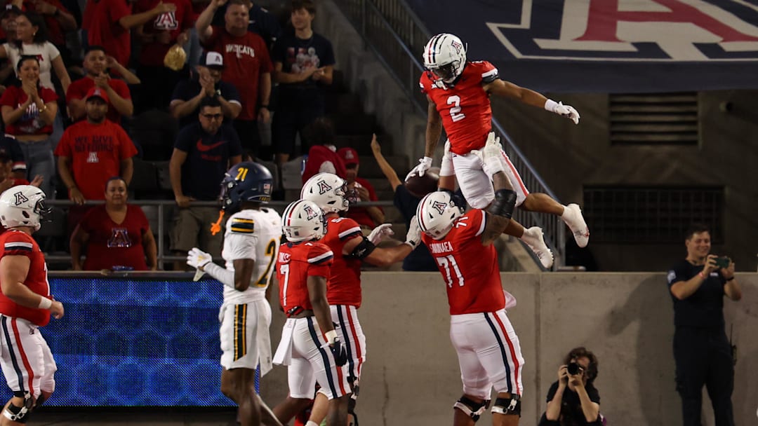 Sep 7, 2024; Tucson, Arizona, USA; Arizona Wildcats wide receiver Jeremiah Patterson (2) celebrates a touchdown with Arizona Wildcats offensive lineman Jonah Savaiinaea (71) during the third quarter against Northern Arizona Lumberjacks at Arizona Stadium.