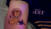 A tattoo of the Detroit Lions vs. Minnesota Vikings matchup is shown.