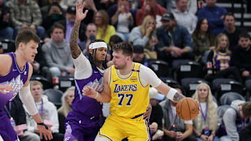 Feb 12, 2025; Salt Lake City, Utah, USA;  Los Angeles Lakers guard Luka Doncic (77) dribbles against Utah Jazz guard Jordan Clarkson (00) during the second half at Delta Center. Mandatory Credit: Chris Nicoll-Imagn Images