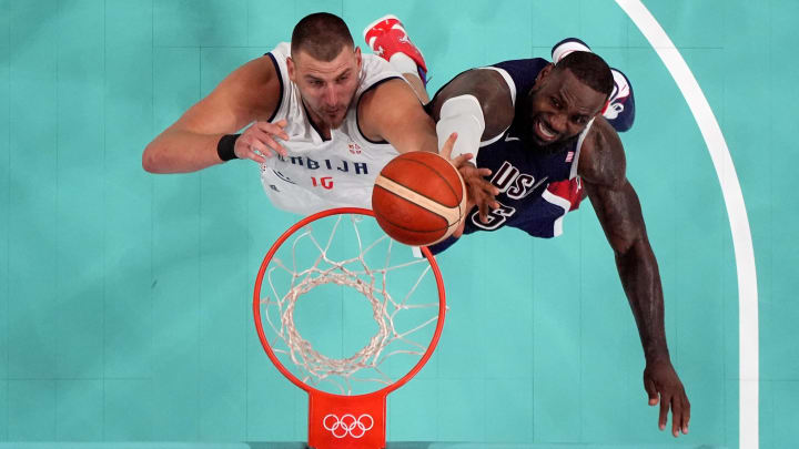 Jul 28, 2024; Villeneuve-d'Ascq, France; Serbia power forward Nikola Jokic (15) and United States guard LeBron James (6) jump for a rebound in the fourth quarter during the Paris 2024 Olympic Summer Games at Stade Pierre-Mauroy. Mandatory Credit: John David Mercer-USA TODAY Sports