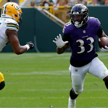 Baltimore Ravens running back John Kelly (33) carries the ball against Green Bay Packers linebacker Ralen Goforth (44) during a preseason game.