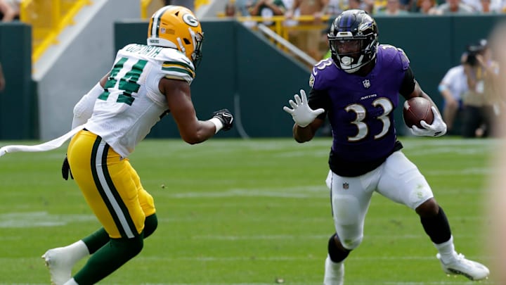 Baltimore Ravens running back John Kelly (33) carries the ball against Green Bay Packers linebacker Ralen Goforth (44) during a preseason game.