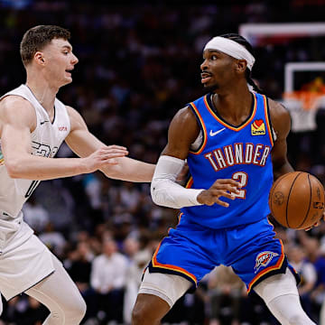 May 15, 2025; Denver, Colorado, USA; Oklahoma City Thunder guard Shai Gilgeous-Alexander (2) controls the ball as Denver Nuggets guard Christian Braun (0) guards in the second quarter during game six of the second round for the 2025 NBA Playoffs at Ball Arena. Mandatory Credit: Isaiah J. Downing-Imagn Images