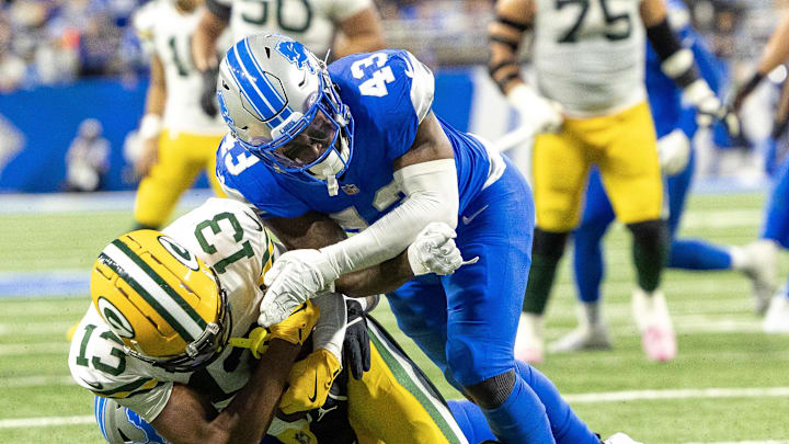 Detroit Lions linebacker David Long Jr. (43) tackles Green Bay Packers wide receiver Dontayvion Wicks (13) 