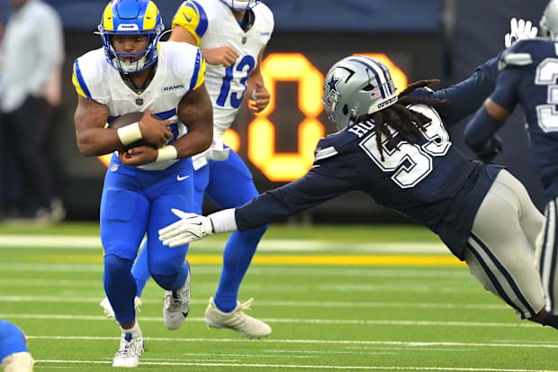 Los Angeles Rams running back Jarquez Hunter carries the ball past Dallas Cowboys EDGE James Houston.