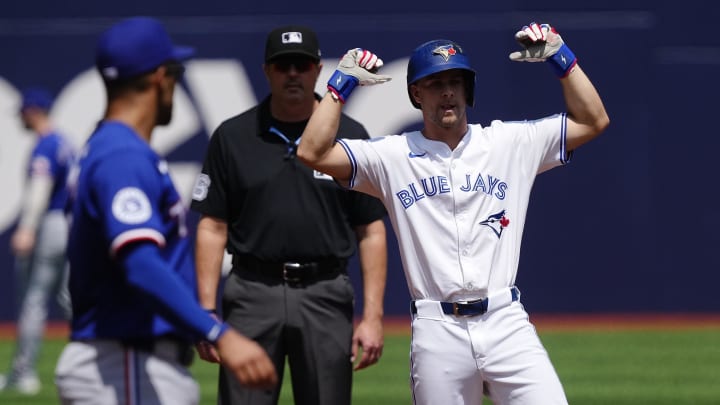 Jul 28, 2024; Toronto, Ontario, CAN; Toronto Blue Jays third baseman Ernie Clement (28) celebrates his double as  Texas Rangers shortstop Corey Seager (5) looks on during the first inning at Rogers Centre. Mandatory Credit: John E. Sokolowski-USA TODAY Sports