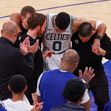 May 12, 2025; New York, New York, USA; Boston Celtics forward Jayson Tatum (0) is helped off the court by after an injury in the second half during game four of the second round for the 2025 NBA Playoffs against the New York Knicks at Madison Square Garden. Tatum would leave the game with an injury after this play. Mandatory Credit: Vincent Carchietta-Imagn Images