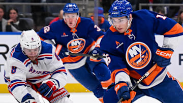 Apr 10, 2025; Elmont, New York, USA;  New York Islanders center Marc Gatcomb (16) attempts a shot defended by New York Rangers left wing J.T. Miller (8) during the second period at UBS Arena. Mandatory Credit: Dennis Schneidler-Imagn Images
