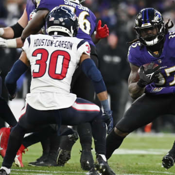 Jan 20, 2024; Baltimore, MD, USA; Baltimore Ravens running back Gus Edwards (35) runs the ball against Houston Texans safety DeAndre Houston-Carson (30) during the second quarter  in a 2024 AFC divisional round game at M&T Bank Stadium. Mandatory Credit: Tommy Gilligan-USA TODAY Sports