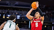 Mar 15, 2025; Indianapolis, IN, USA; Wisconsin Badgers guard John Tonje (9) shoots the ball while Michigan State Spartans guard Jeremy Fears Jr. (1) defends in the second half  at Gainbridge Fieldhouse.