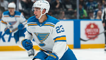 Oct 13, 2025; Vancouver, British Columbia, CAN; Vancouver Canucks forward Arshdeep Bains (13) shoots around St. Louis Blues defenseman Logan Mailloux (23) in the second period at Rogers Arena. Mandatory Credit: Bob Frid-Imagn Images