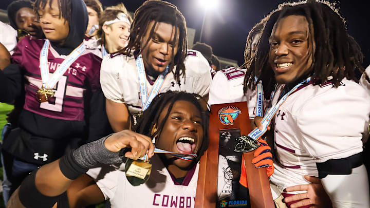 Madison County Cowboys Kemari Scurry (1) holds the State Championship trophy while waving his medal. The Hawthorne Hornets played the Madison County Cowboys in the 1R State Championship at The Range at HG Morse Stadium in Sumterville, FL on Friday, December 6, 2024. The Madison County Cowboys defeated the Hawthorne Hornets 21-14. [Doug Engle/Gainesville Sun]