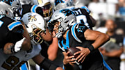 Nov 9, 2025; Charlotte, North Carolina, USA; Carolina Panthers quarterback Bryce Young (9) scrambles as New Orleans Saints defensive end Chase Young (99) pressures in the third quarter at Bank of America Stadium. Mandatory Credit: Bob Donnan-Imagn Images