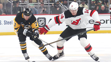 Mar 15, 2025; Pittsburgh, Pennsylvania, USA;  Pittsburgh Penguins center Evgeni Malkin (71) and New Jersey Devils right wing Nathan Bastian (14) battle for the puck during the second period at PPG Paints Arena. Mandatory Credit: Charles LeClaire-Imagn Images