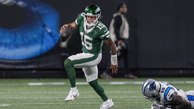  New York Jets quarterback Adrian Martinez (15) gets away from a tackle by Carolina Panthers defensive end 