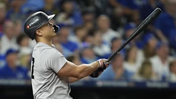 Oct 9, 2024; Kansas City, Missouri, USA; New York Yankees designated hitter Giancarlo Stanton (27) hits a home run in the eighth inning against the Kansas City Royals during game three of the NLDS for the 2024 MLB Playoffs at Kauffman Stadium. Mandatory Credit: Jay Biggerstaff -Imagn Images