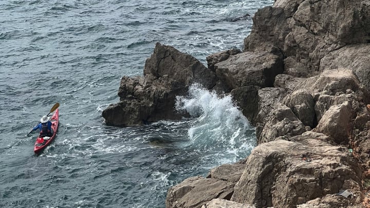 Kayaker Paddling Along the Shoreline