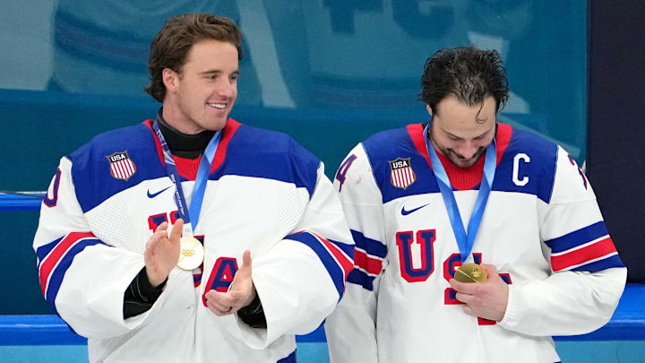 Feb 22, 2026; Milan, Italy; Jake Oettinger and Auston Matthews of the United States celebrate after winning the men's ice hockey gold medal game during the Milano Cortina 2026 Olympic Winter Games at Milano Santagiulia Ice Hockey Arena. Mandatory Credit: James Lang-Imagn Images
